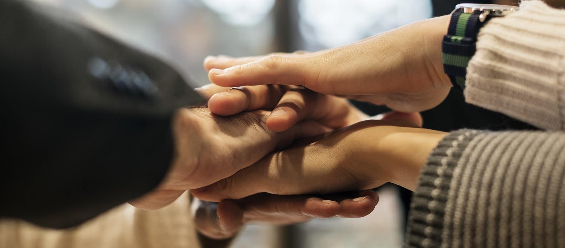 Quatro pessoas com as mãos uma sobre a outra