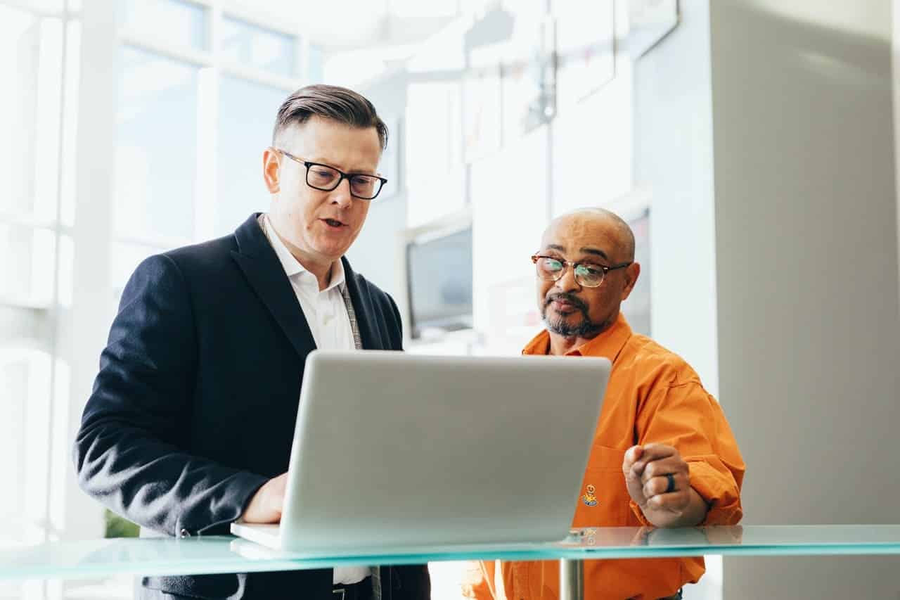 Homens conversando e olhando para um notebook