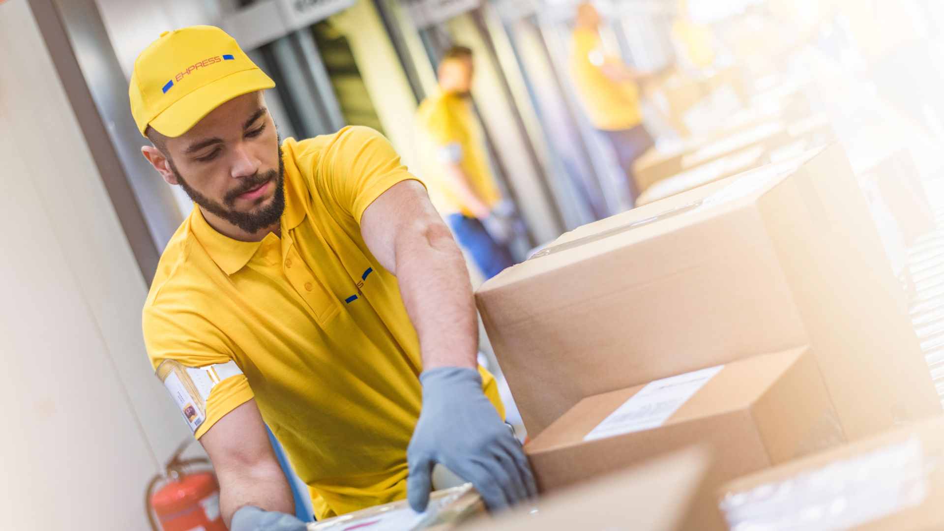 Imagem de pessoas trabalhando em um centro de distribuição, tendo um homem em foco.
