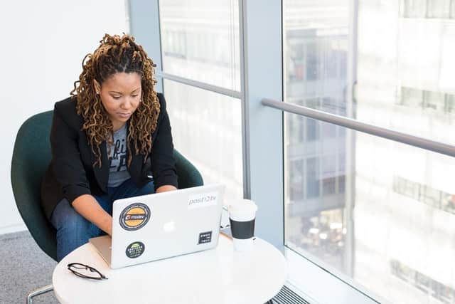 Mulher sentada em uma cadeira digitando em um notebook