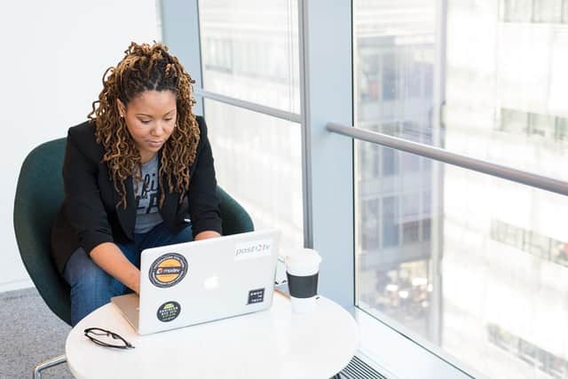 Mulher sentada em uma cadeira digitando em um notebook