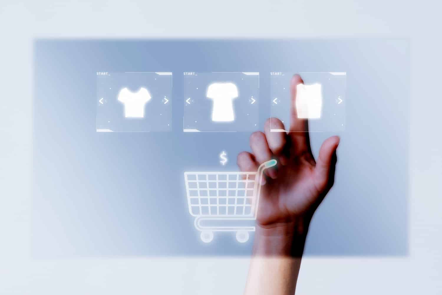 Uma mão clicando em itens de roupa e colocando em um carrinho de compras.