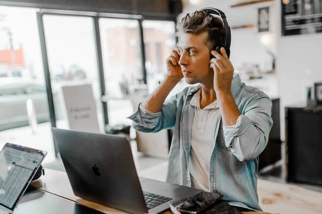 Homem com fone de ouvido e notebook