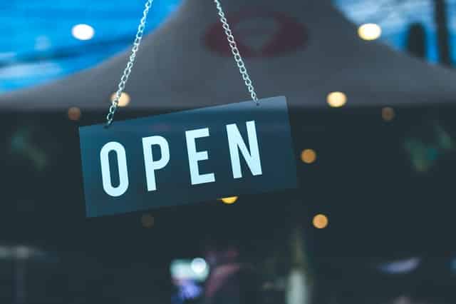 Placa de "open" pendurada em uma vitrine