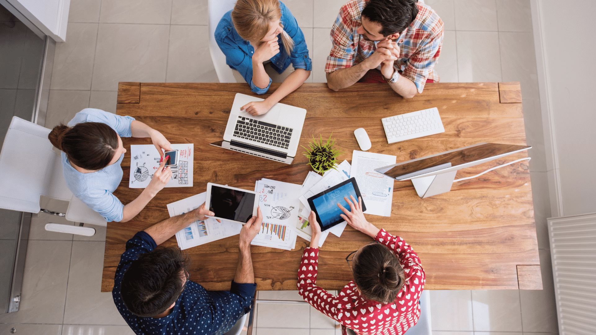 Grupo de pessoas reunidas em uma mesa conversando e decidindo nome da empresa