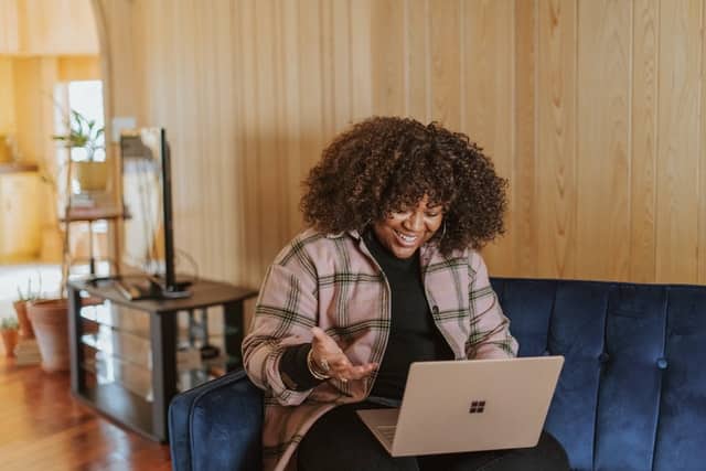 Mulher sorrindo com notebook no colo